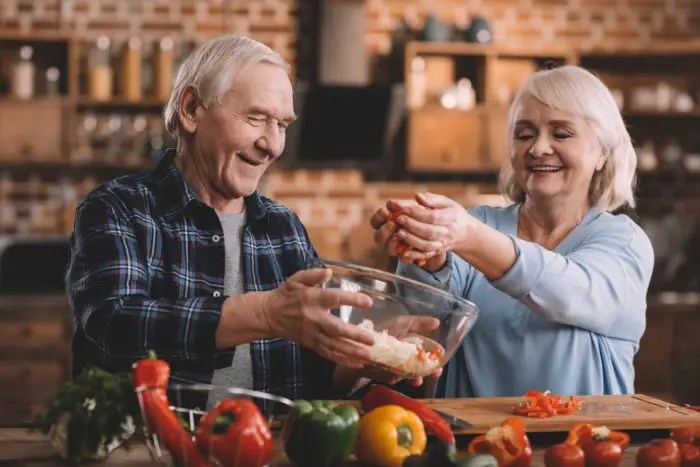 Elderly couple preparing a healthy meal together using Boulder Salt, a salt alternative for health and well-being