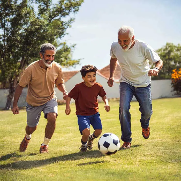 Grandfather, father, and son playing soccer outdoors while promoting health with Boulder Salt, a healthy salt alternative